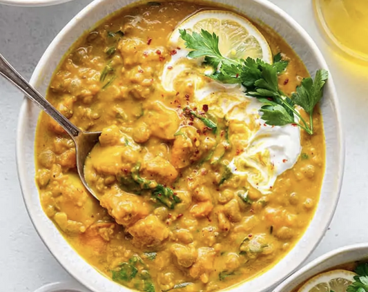 Creamy golden lentil soup with fresh herbs, coconut yogurt, and lemon — comforting, rich, and flavorful.
