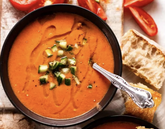Chilled gazpacho garnished with diced cucumbers and a drizzle of olive oil—refreshing, tangy, and perfect for a summer meal.