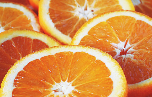 Close-up of vibrant, juicy orange slices overlapping each other, highlighting their bright color and fresh, citrusy texture.