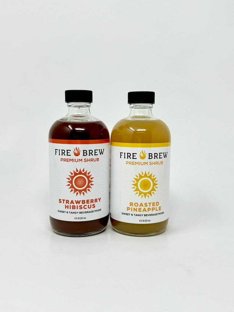 Two Fire Brew apple cider vinegar shrubs—Strawberry Hibiscus and Roasted Pineapple—on white background.