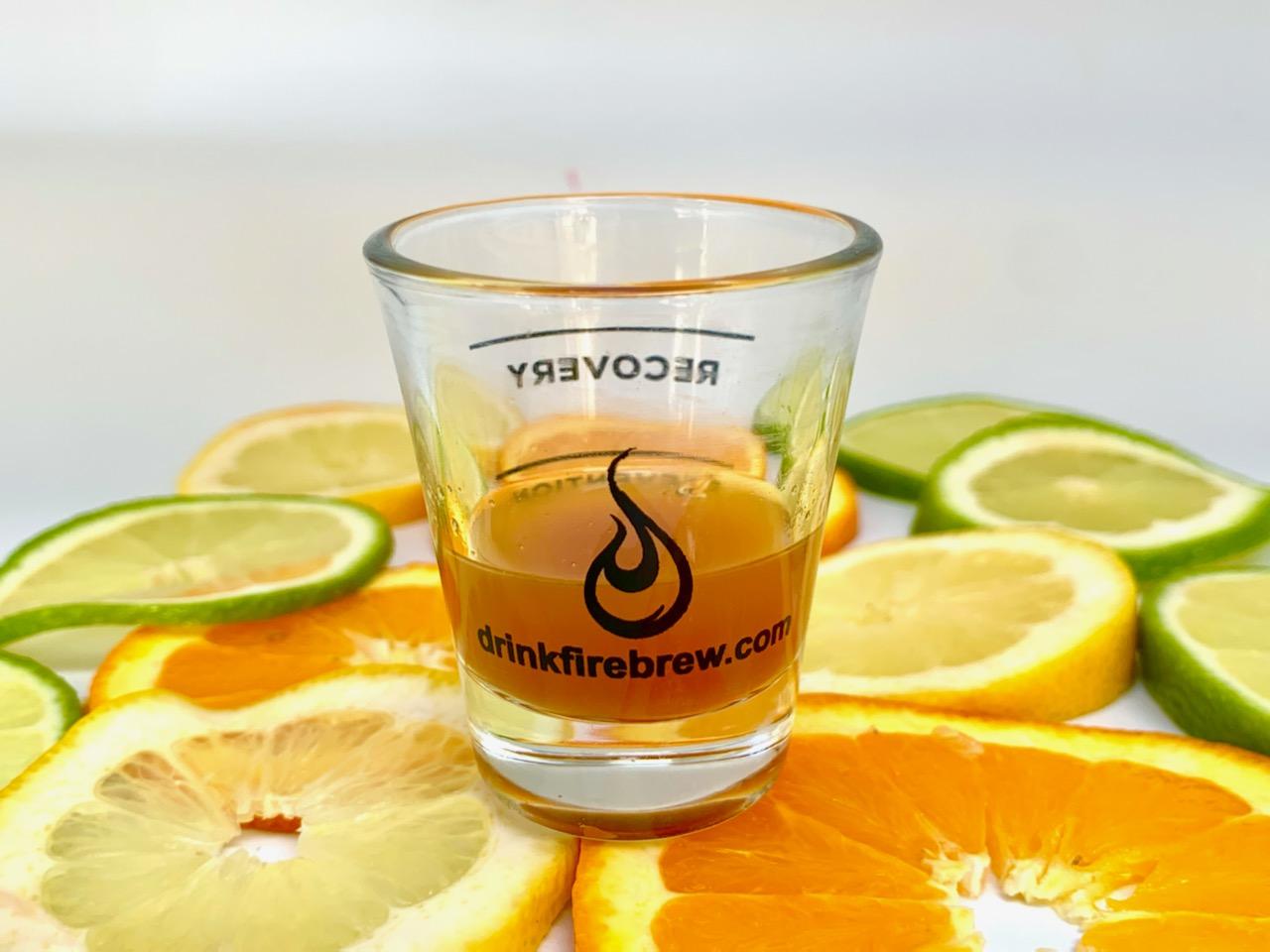 A glass of Fire Brew apple cider vinegar tonic surrounded by fresh citrus slices for a vibrant display.