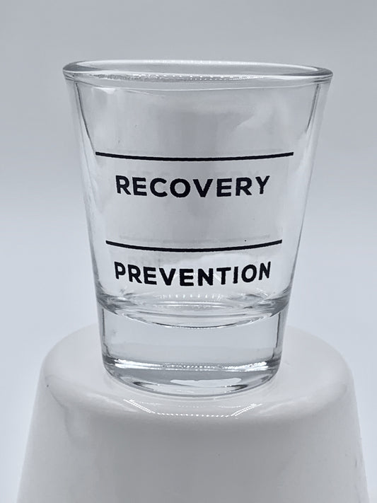 Clear Fire Brew shot glass with black text "Recovery" and "Prevention" on a white background.
