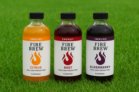 Fire Brew apple cider vinegar tonic bottles on grass, fire cider for gut cleanse and wellness.