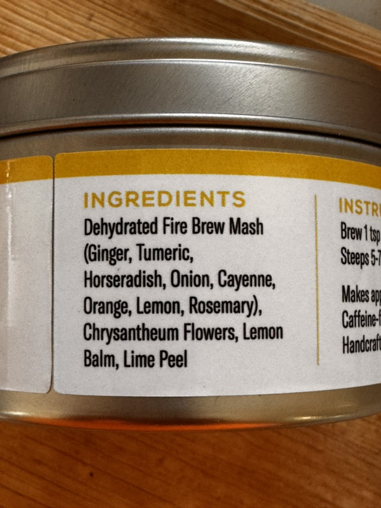 Fire Brew Golden Ember tea ingredients label showing ginger, turmeric, citrus, herbs, and flowers.